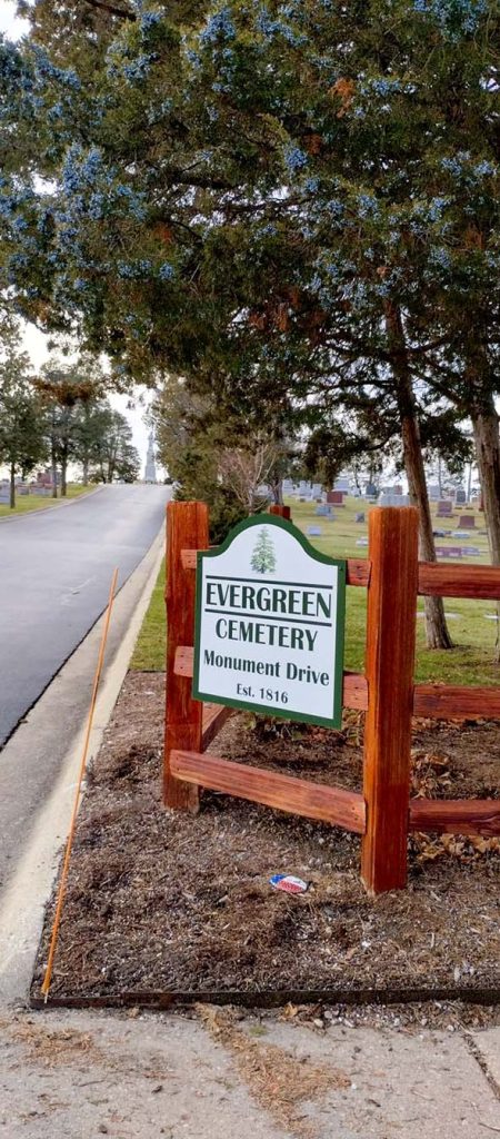 Photograph of a sign indicating the entrance to Evergreen Cemetery, established 1816.