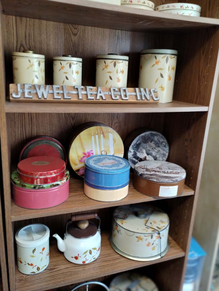 Photograph of Jewel Tea Company's Autumn Leaf cookie jars and containers on shelves.