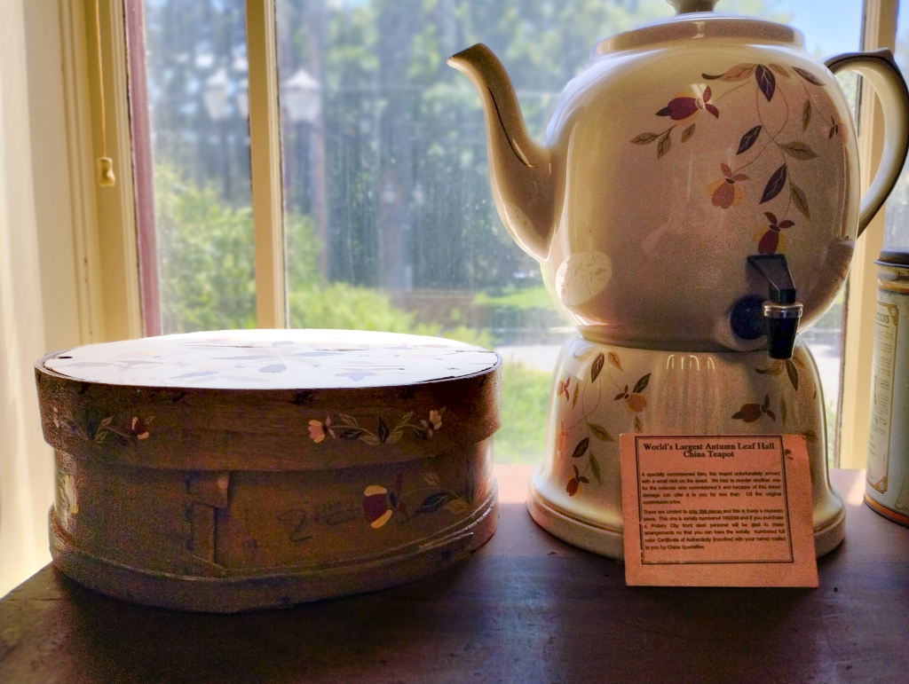 Photograph of the World's largest Autumn Leaf china teapot alongside a round box.